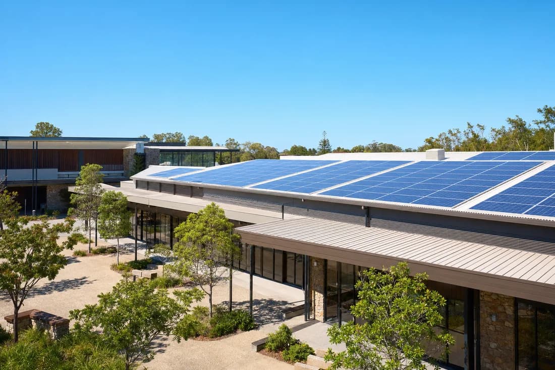 A strip of neighbourhood shops with a solar array along the roof above them