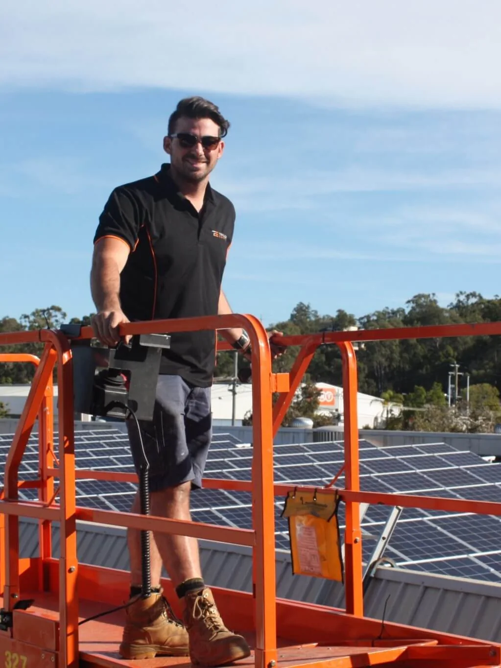 One of our installers on a lift beside a completed commercial rooftop array