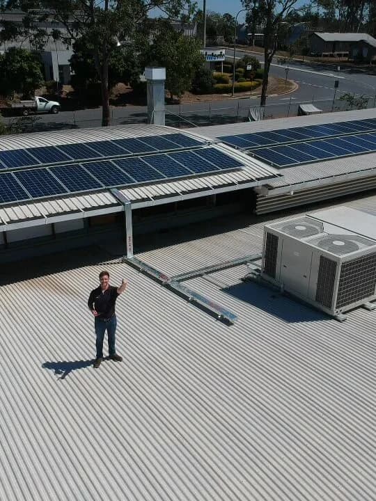 A member of our team on the roof of a completed commercial solar installation